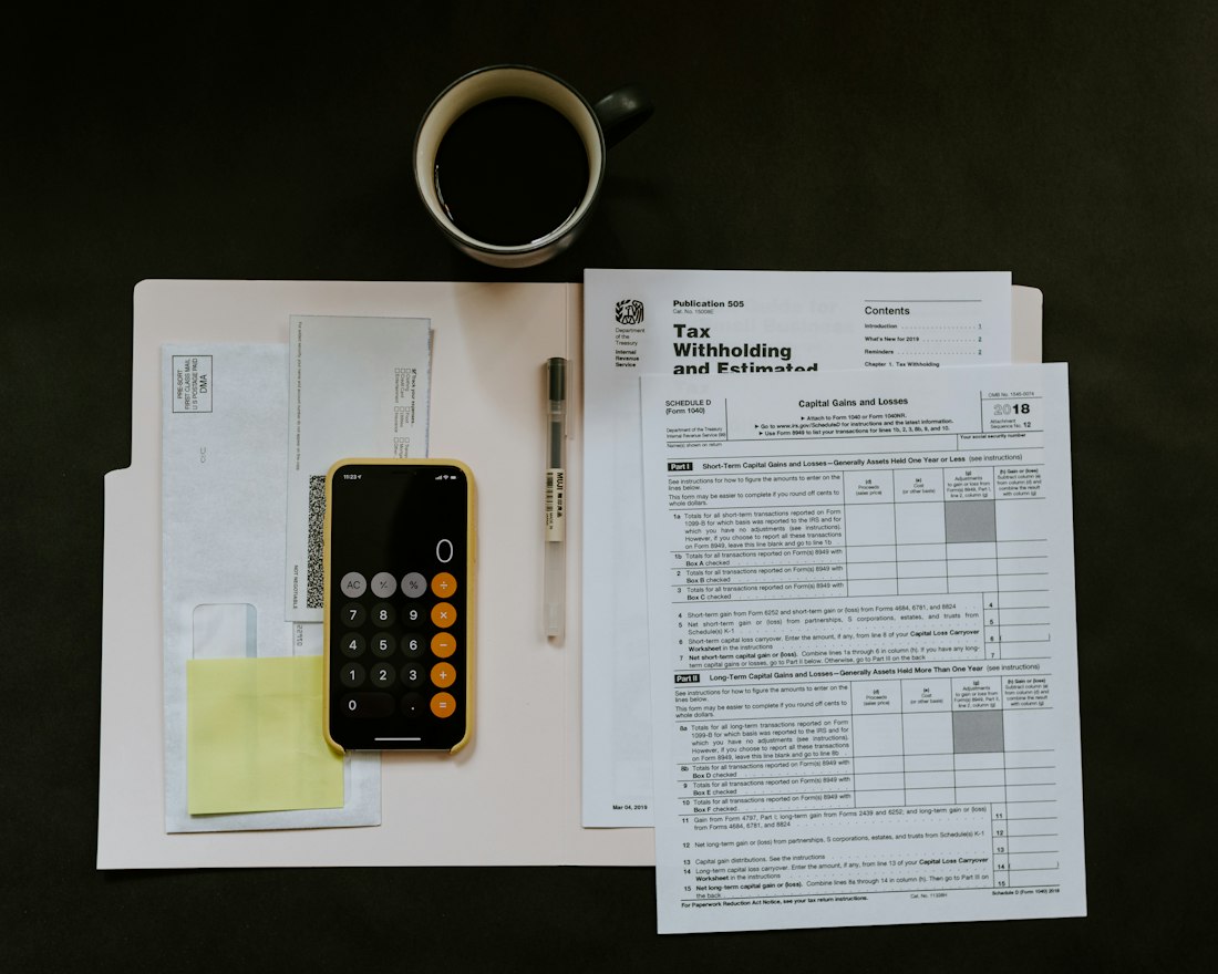 Organized financial documents, a calculator, and a pen on a desk